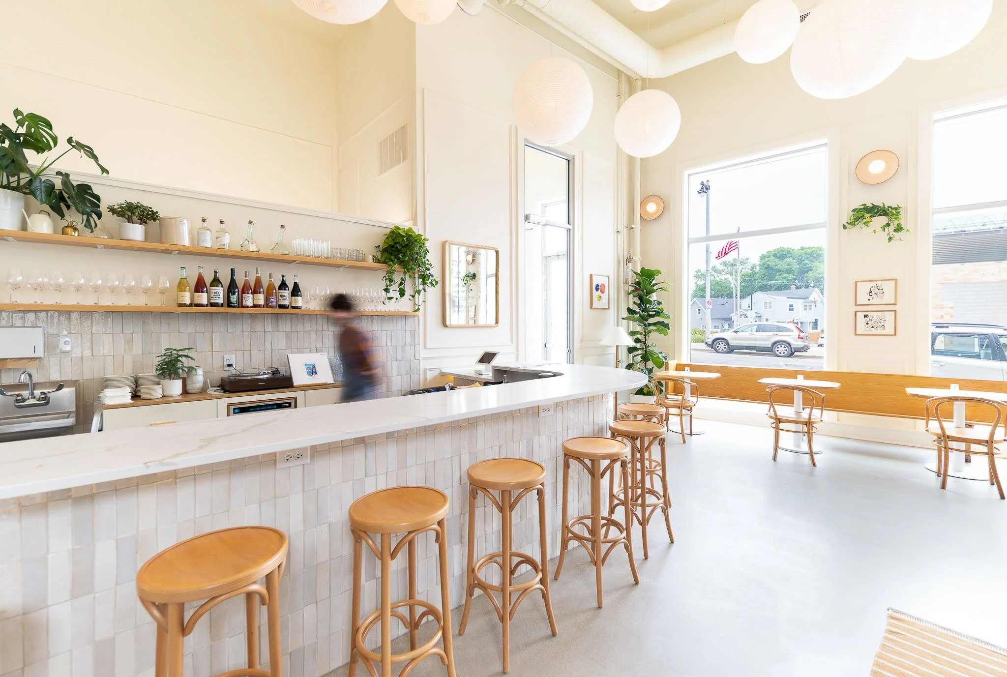Minimalist wine bar detail with globe wall sconces and clean white shelving — Milwaukee Non-Fiction wine bar commercial interior photography
