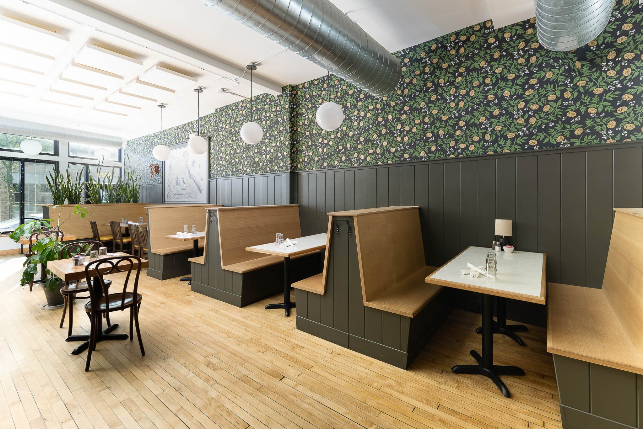 Warm and eclectic restaurant dining room with globe pendant lights and wood accents — Milwaukee Honey Pie restaurant commercial interior photography