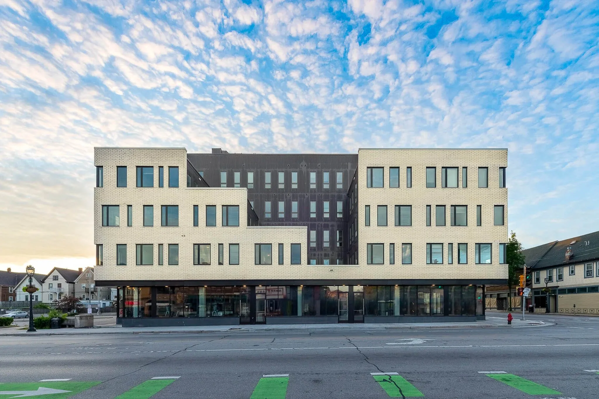 Contemporary mixed-use commercial building exterior at dusk with warm interior light — Milwaukee commercial architecture photography