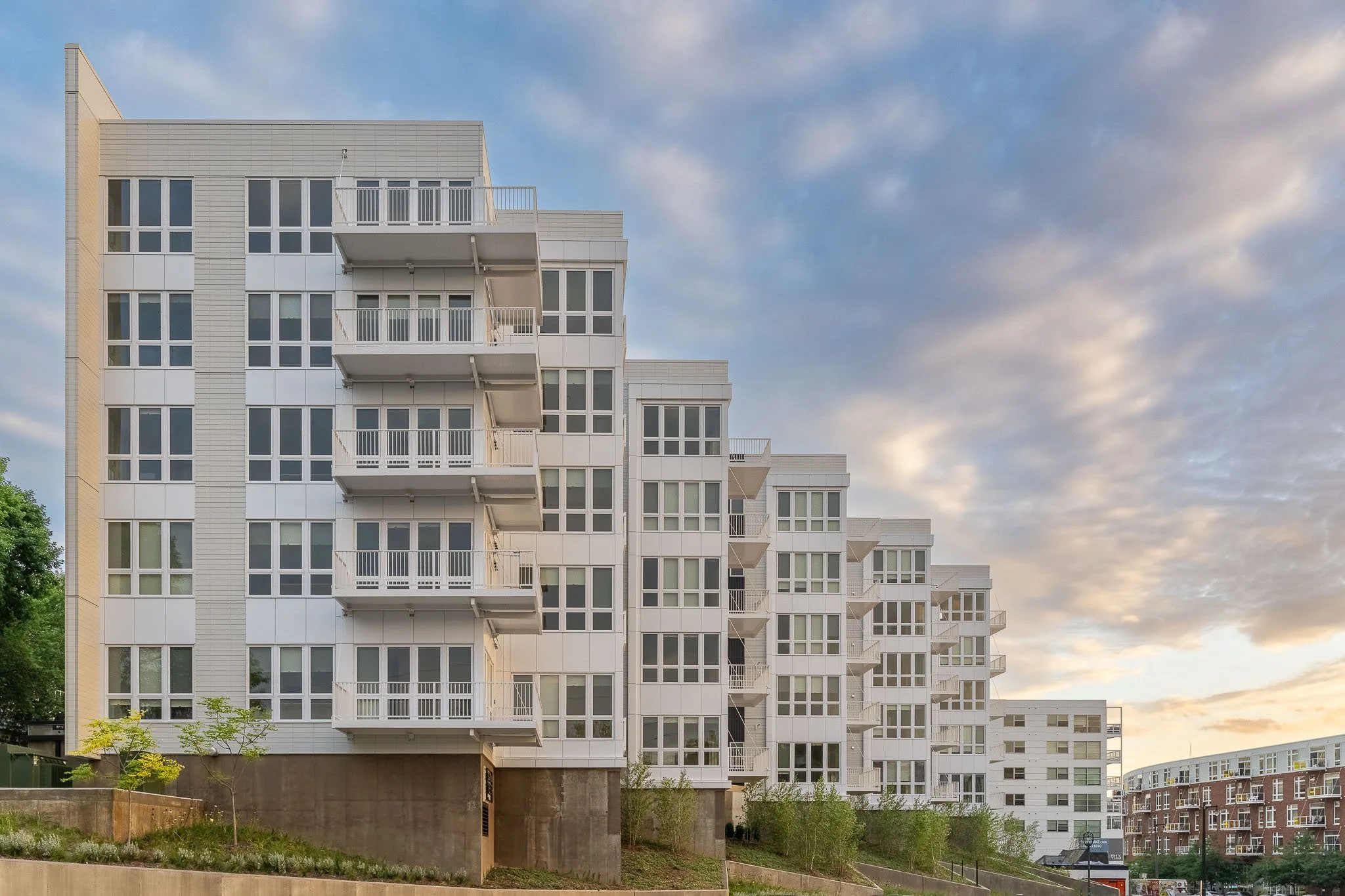 White modern apartment building with stepped balconies and cantilevered floors at dusk — Milwaukee 1659 Jackson residential architecture photography