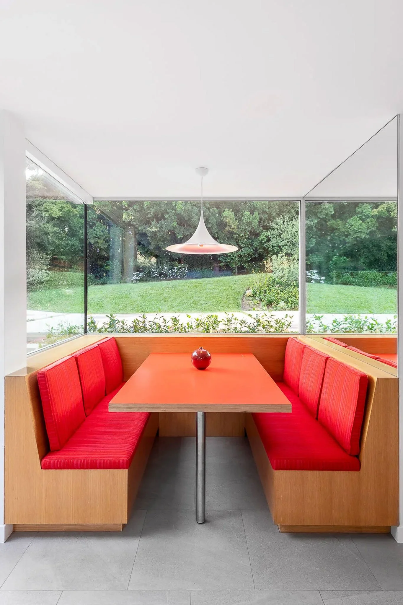 Red U-shaped banquette breakfast nook with built-in bench seating — California modern residence interior photography