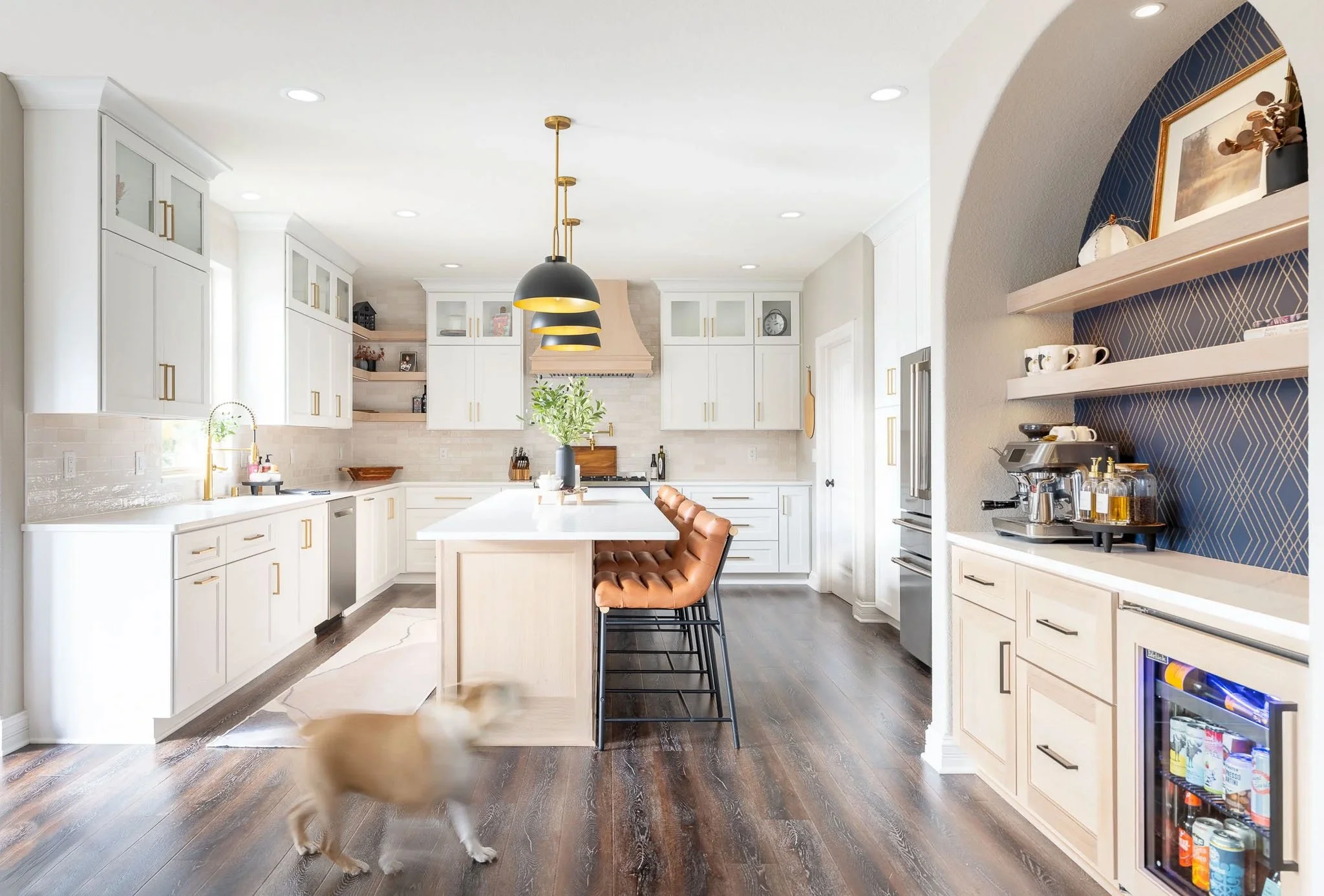 Wide-angle white kitchen with blue diamond tile archway, espresso station, and leather bar stool — Milwaukee residential interior photography