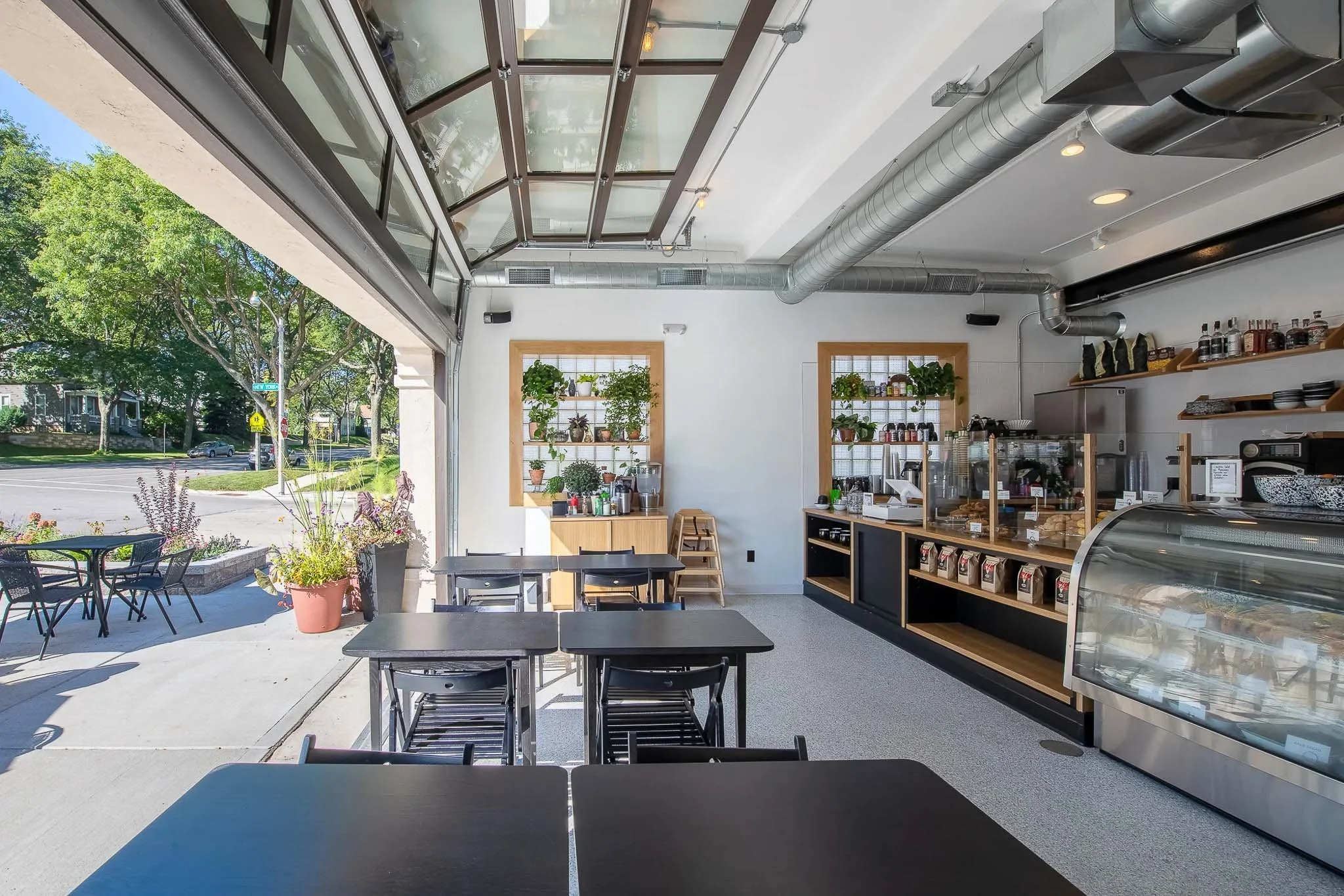 Bright open-concept café and bakery with white subway tile, wood bar stools, and natural light — Milwaukee commercial interior photography