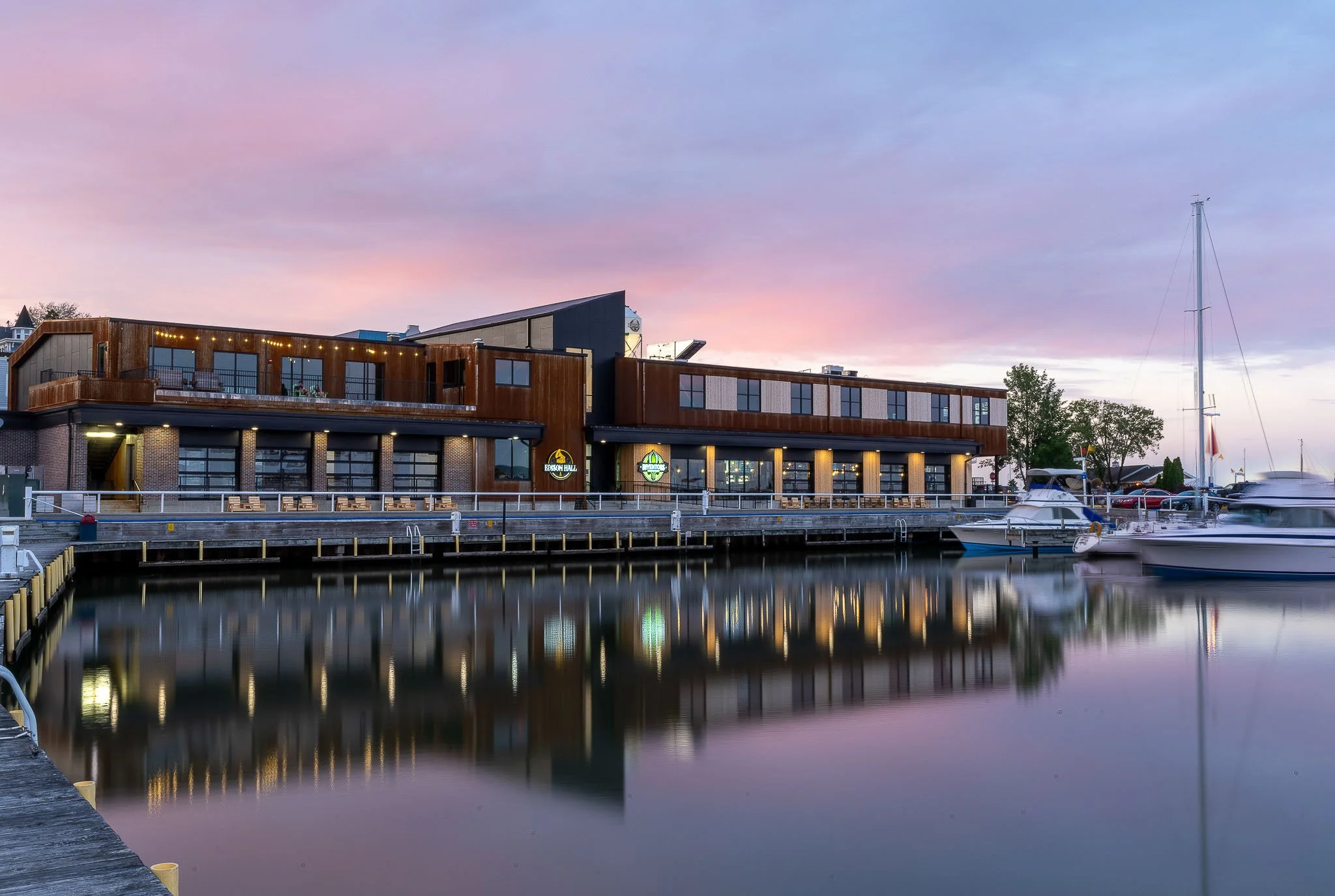 Waterfront commercial building reflected at sunset with marina and dramatic sky — Wisconsin lakefront commercial architecture photography
