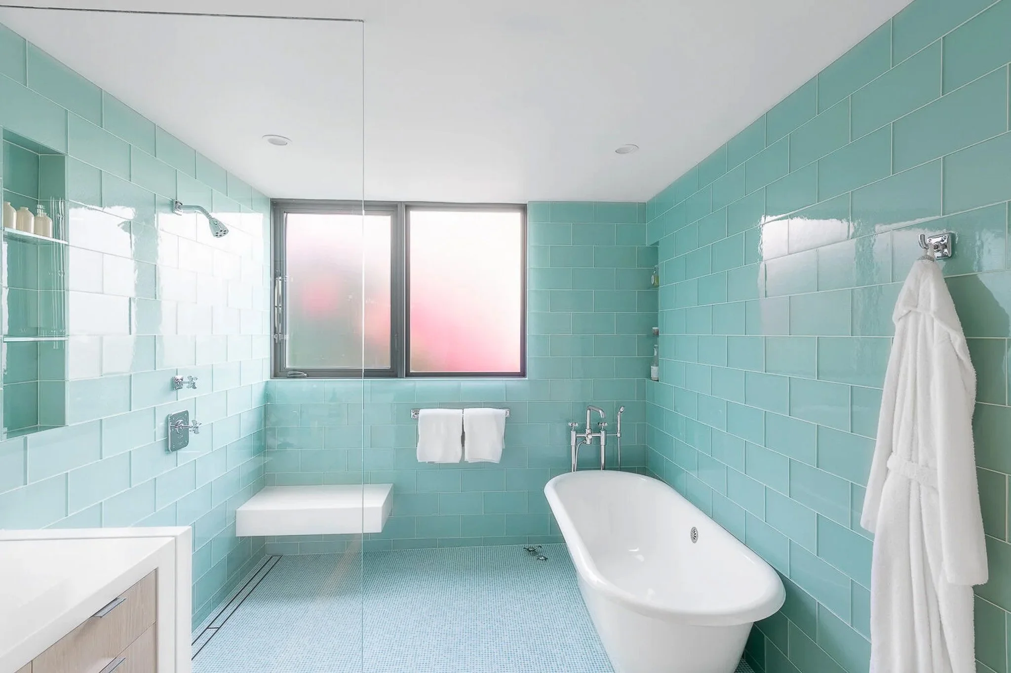 Teal and aqua bathroom with clawfoot soaking tub, pink frosted window, floor-to-ceiling teal subway tile, and penny tile floor — California residential interior photography