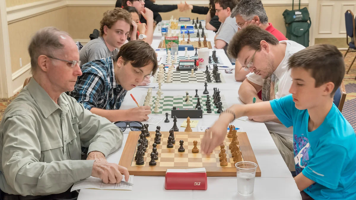 Premier Section Round 4, Board 5: Humberto Cruz (1825) (L) vs Theo Slade (2059) (R); Board 4 Kai Tabor (2051) (L) vs Florida Chess Association President William Bowman (1959) (R).
