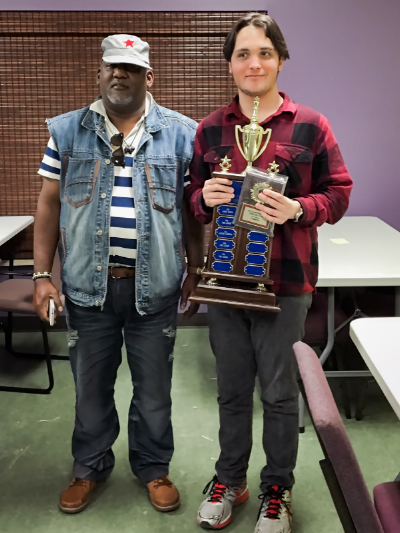 2016 Central Florida Chess Club Champion Kai Tabor (2034) (R) holding the club trophy after winning the event with a half point tiebreak lead over Alfonso Gabbedon (2161) (L) last weekend.