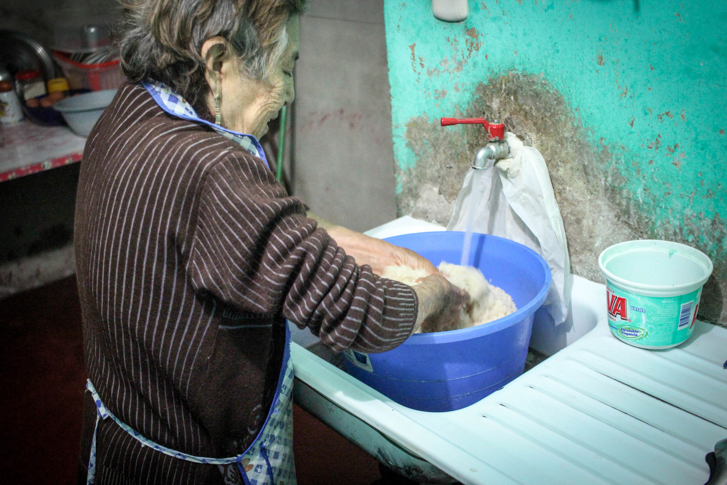 Esperanza washing 4 kilos of rice. She cooks that much rice every day!
