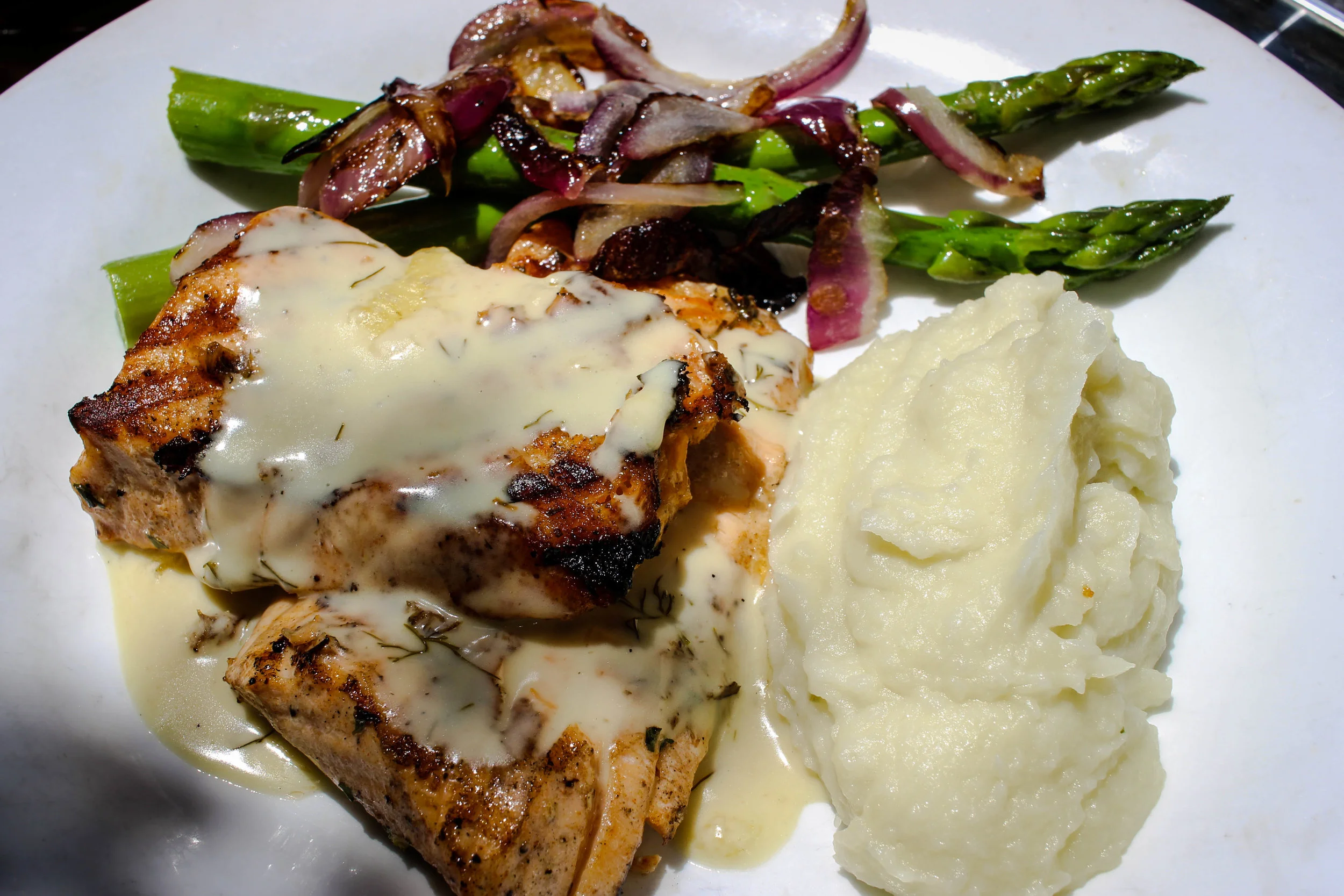 Filet de Saumon grille et puree de pommes de terre, sauce a l'estragon: grilled Salmon filet served with mashed potatoes, tarragon sauce, and asparagus