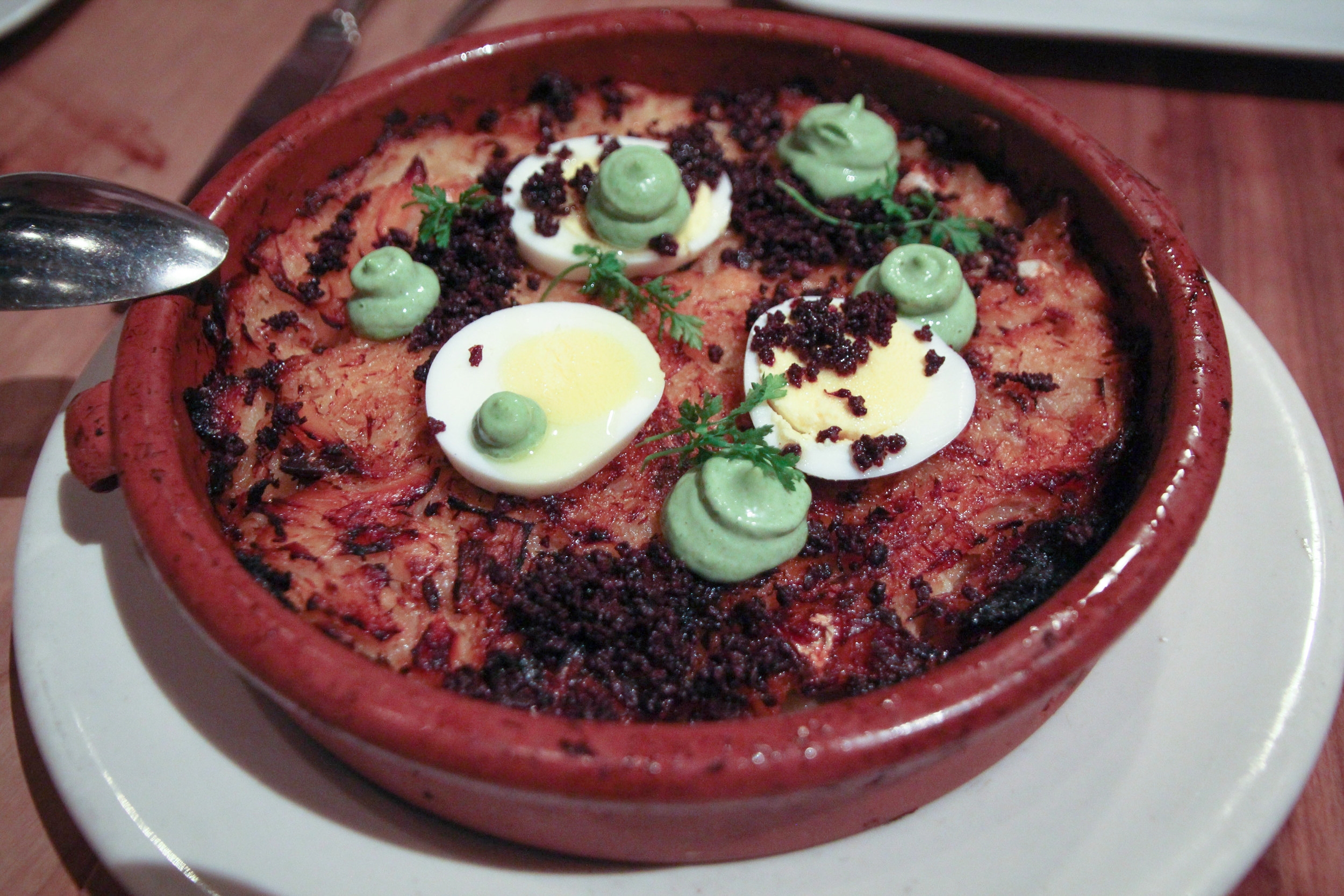 Bacalhau Gomes de Sá: baked salt cod casserole, potatoes, caramelized onions, parsley aioli, crumbled olive, egg