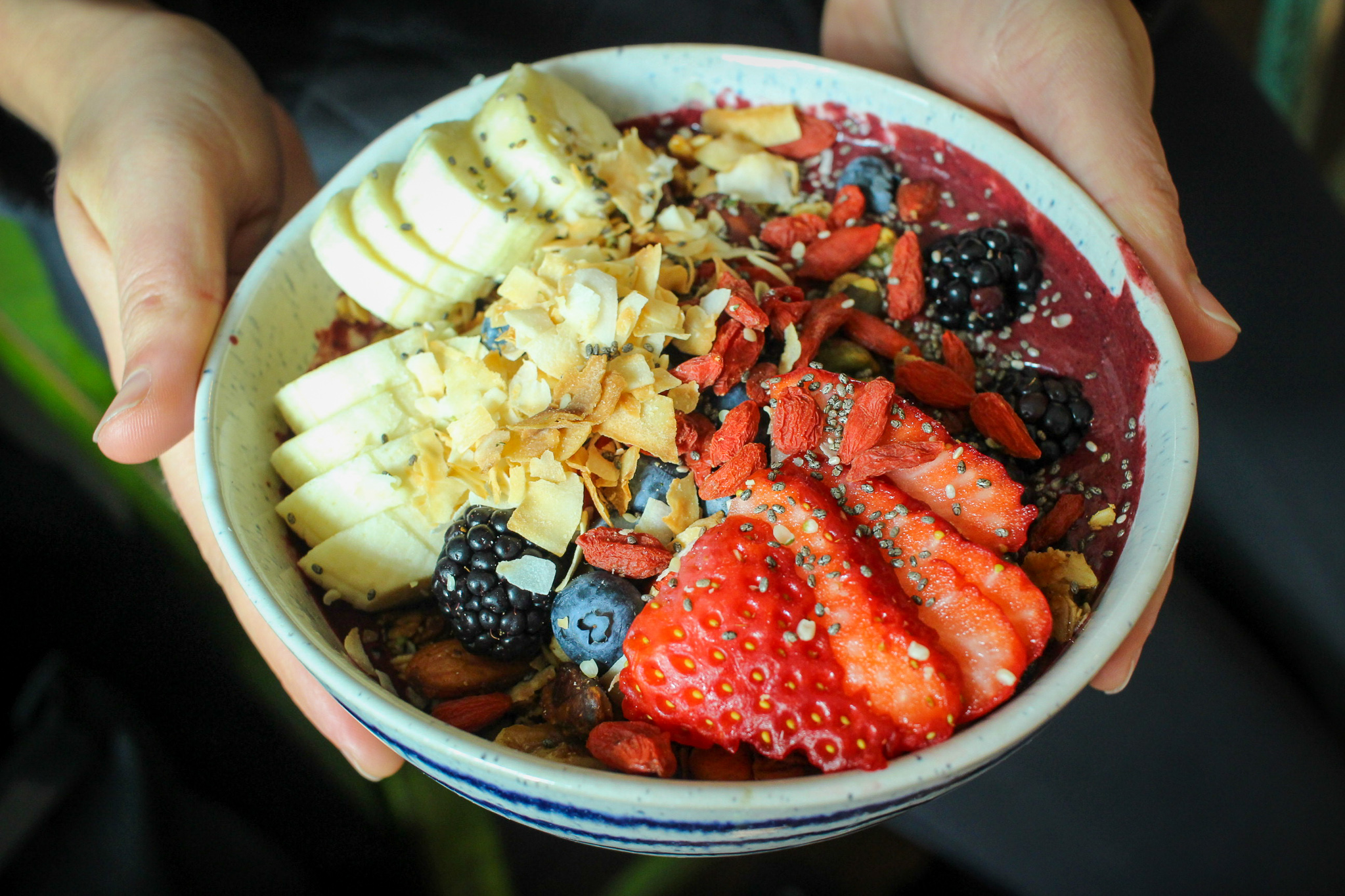 Red velvet smoothie bowl: beet, avocado, berries, date, cocoa, coconut butter, nut milk, and maca–topped with homemade granola, banana, goji berries, cocoa nibs, coconut and hemp seeds.