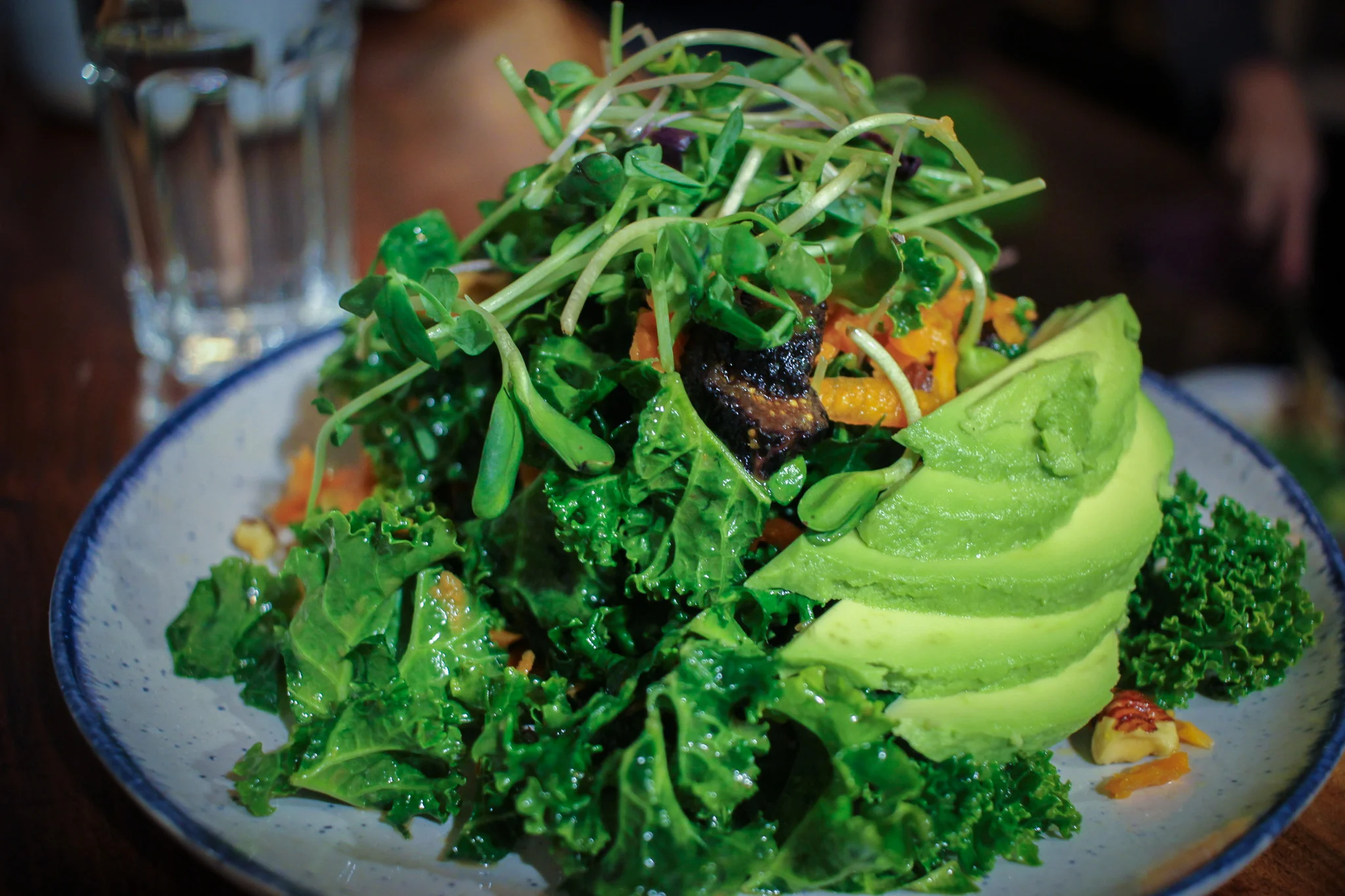 Citrus, hazelnut, and kale salad: kale, carrots, sprouts, orange slices, toasted hazelnuts, dried figs, avocado, and an apple cider vinaigrette.