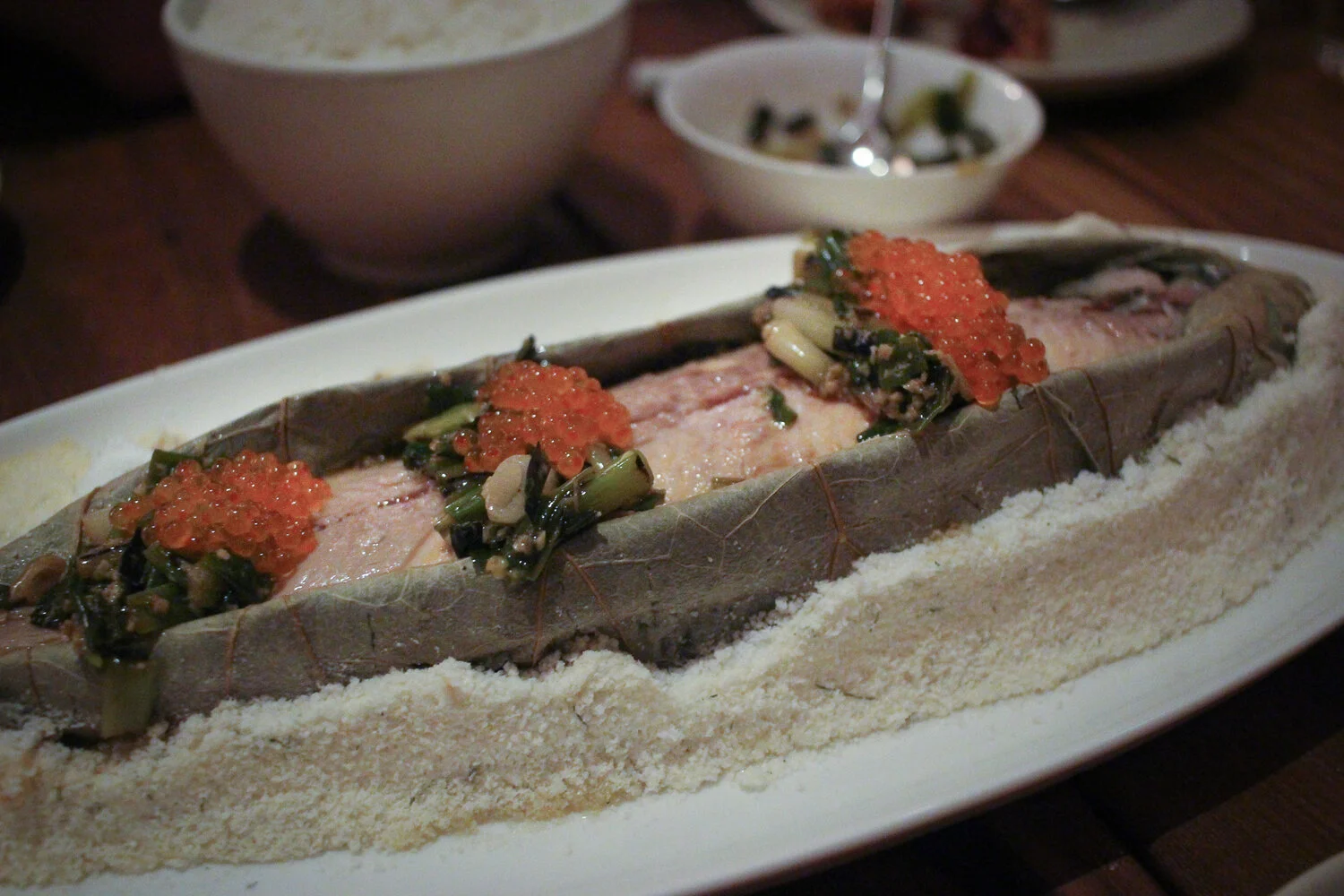 Salt-baked McFarland Springs Trout wrapped in a lotus leaf and served whole with trout roe and charred scallions