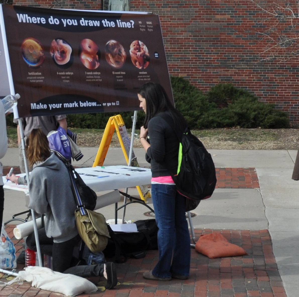 Amanda kneels to make her mark signifying that she thinks human rights begin at fertilization.