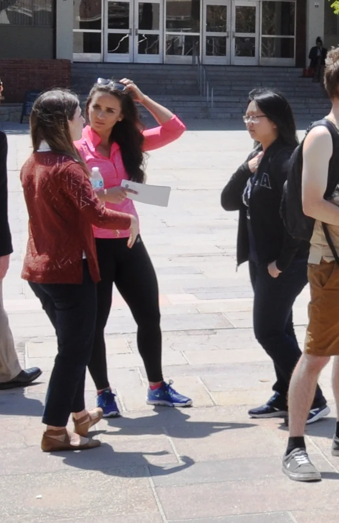  Meredith, of Live Action UCLA (left), and Clare, a leader of the UNLV pro-life club who was visiting UCLA for the day (middle), interact with another university student in front of JFA's   Art of Life  Exhibit  at UCLA in May 2016. 