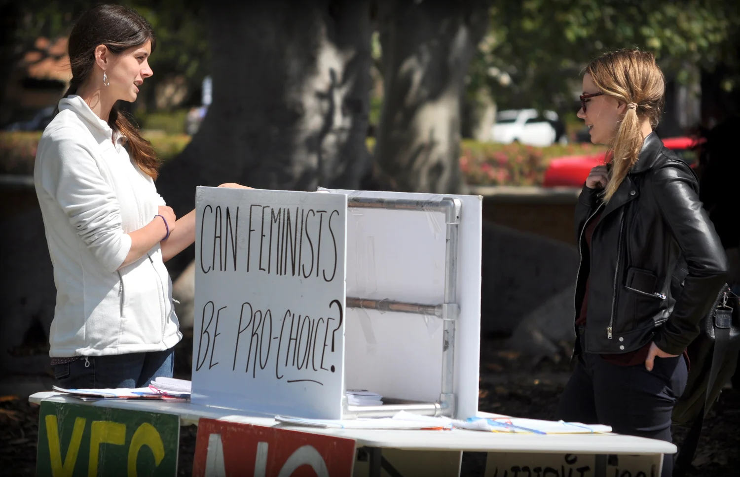 JFA Trainer Rebecca Haschke talks to a UCLA student (May 2016) in front of one JFA poll table asking: "Can feminists be pro-choice?" The poll question's unexpected phrasing prompts many conversations about human equality and the pro-life position.