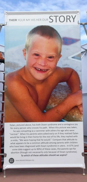 JFA's "Stop and Think" Exhibit features this panel, prompting discussion about what our attitudes should be towards those, like Dylan (shown above), with Down syndrome.