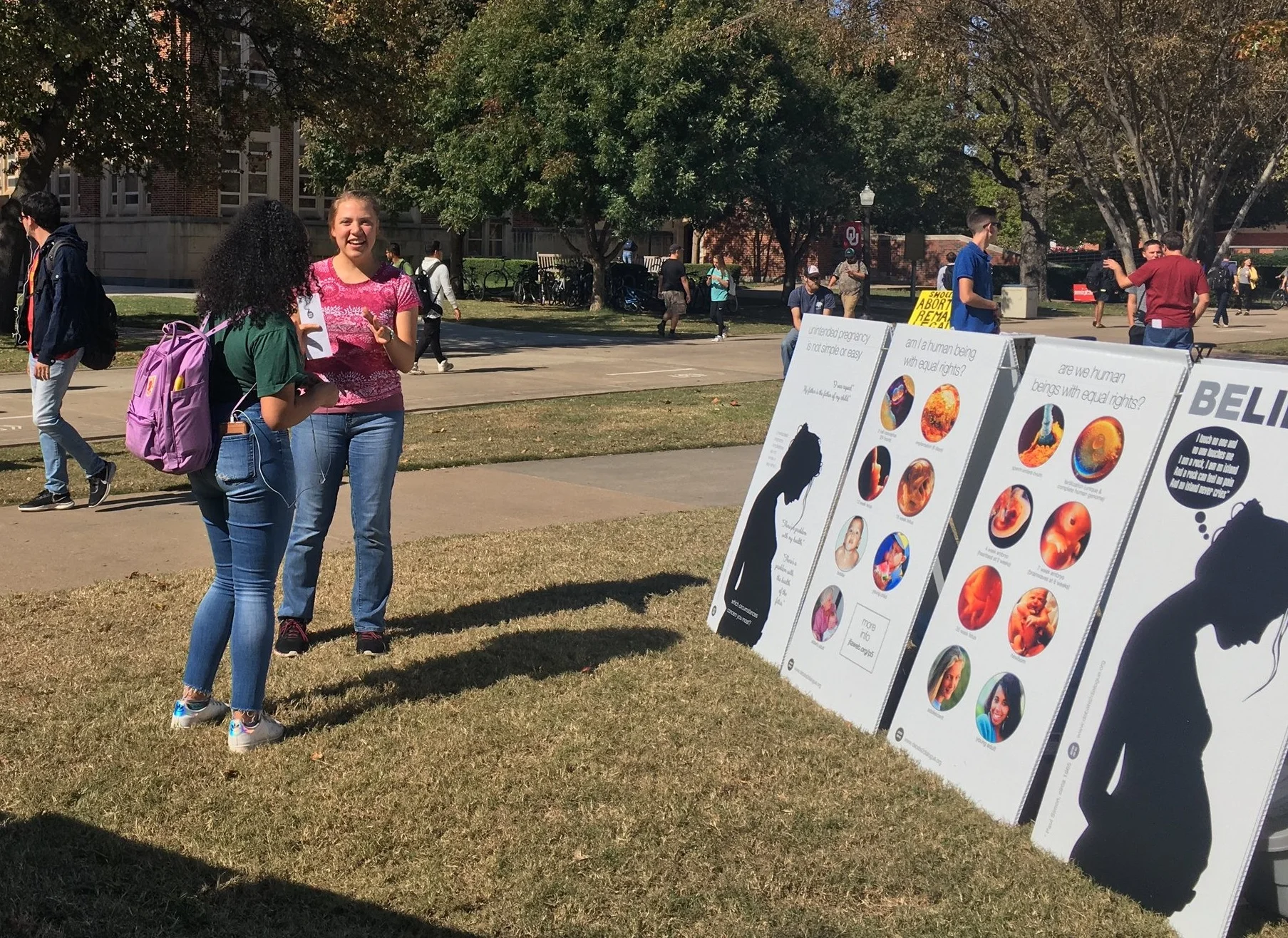 Kaitlyn Donihue (pink) creates conversation at OU. Note how the juxtaposed imagery of mother and child makes it clearer that we care about both.