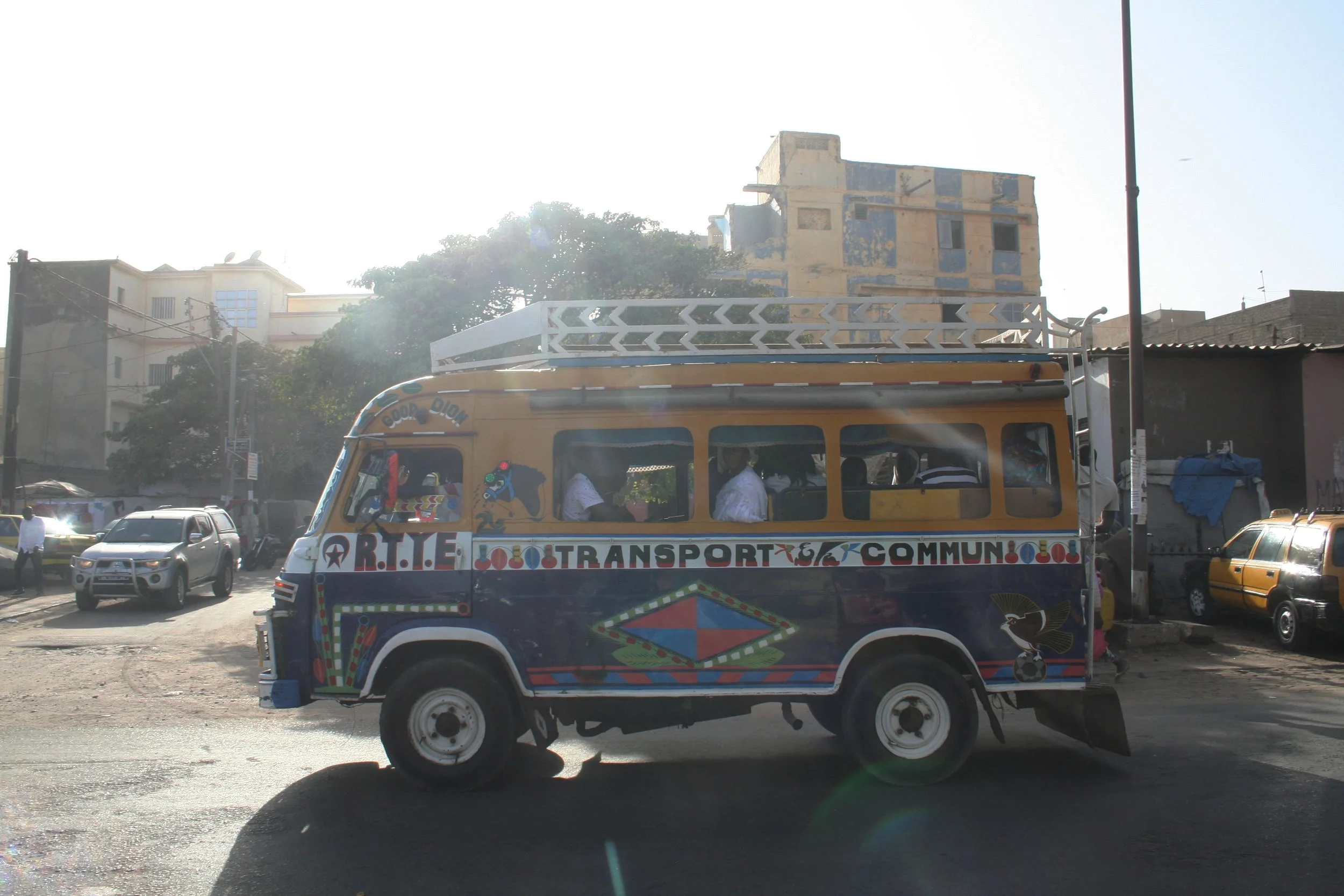  A common form of transportation in Senegal is the “car rapide” a brightly colored van crowded with passengers.   They have no set route and make its up as they pick up passengers.  On highways, there are often two “interns” riding outside on the bac
