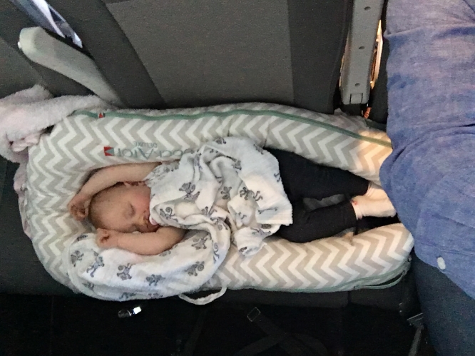 Georgia in her Dock-A-Tot across our laps on the plane