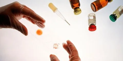 hands reaching for various medications, both pills and injections.