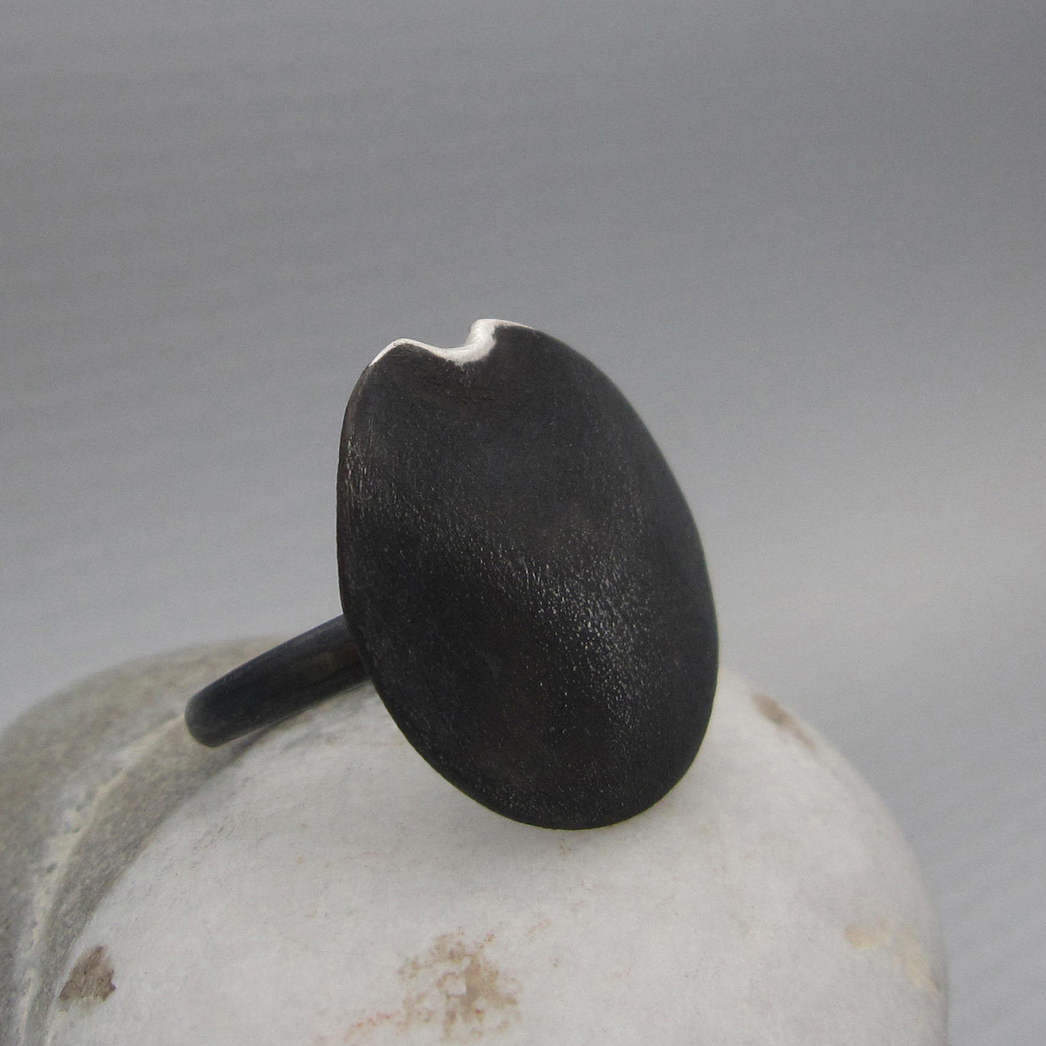 A black patina finishes the design of this moon-inspired ring