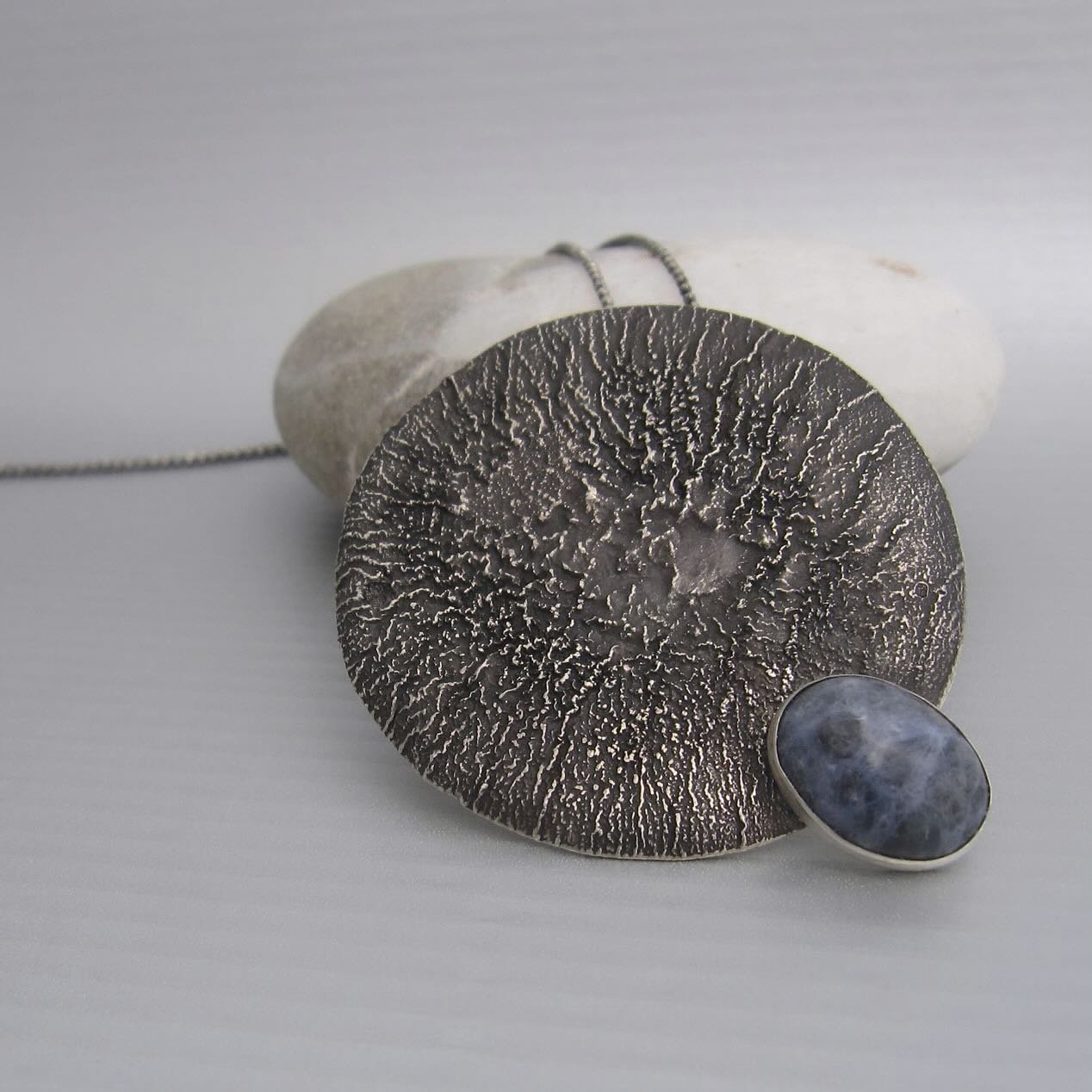 Another one of a kind piece: pianeta e sodalite necklace. Handcrafted in reclaimed sterling silver (using the technique of reticulation) and finished with a sodalite stone.

Image+design&copy;️maddalenabearzi