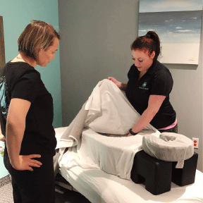 Licensed massage therapists performing safe prenatal massage using a specialized pregnancy cushion for comfort and pelvic pain relief at Massage Hope in Leesburg and Ashburn VA