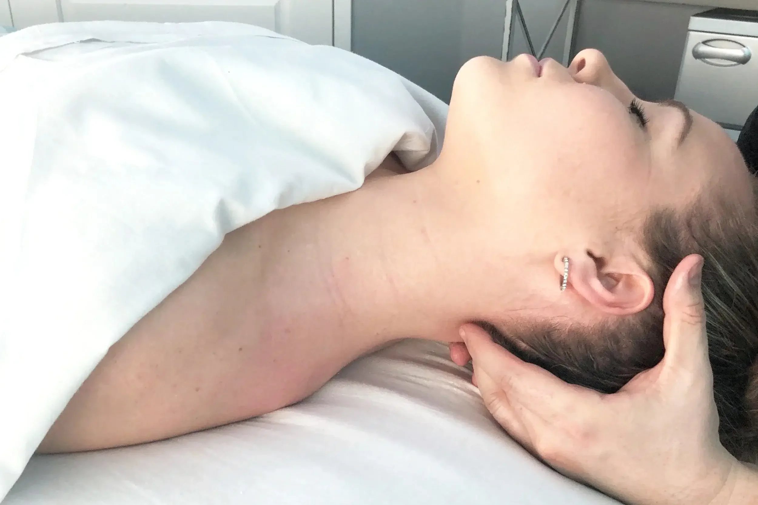 Massage therapist performing targeted neck massage for migraine and tension headache relief on a female client at Massage Hope in Leesburg VA