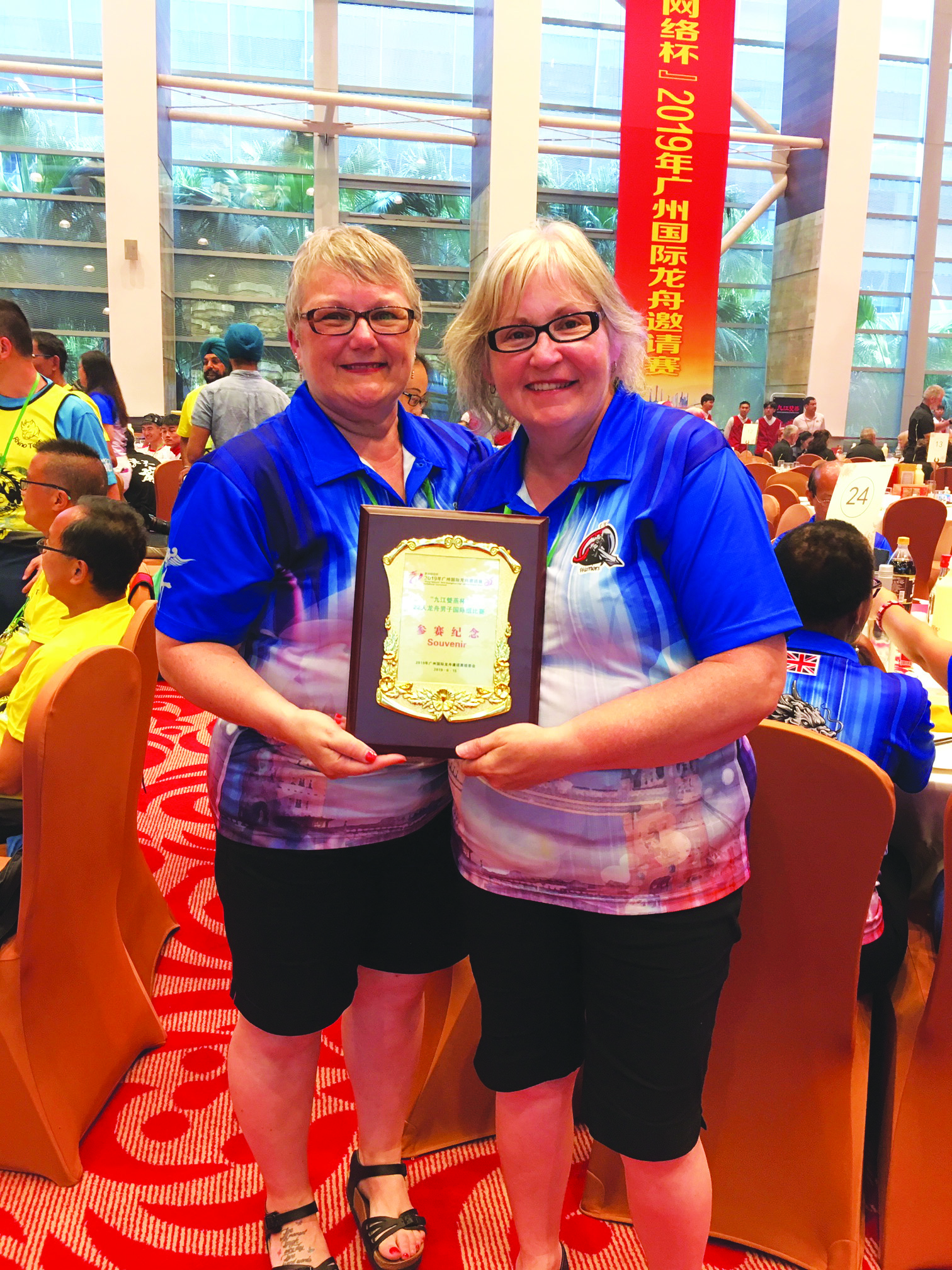 Kitty Whalen (left) and Kay Aylward with a souvenir plaque awarded to their Dragon Boat team in China.