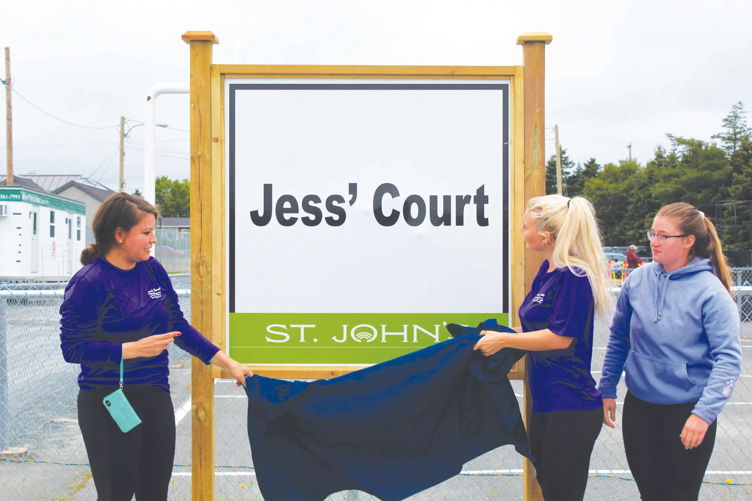 Shania Adams (left), Taylor Hayes (middle), and Rebecca Maher reveal the new sign during the official naming ceremony of Jess’ Court. Chris Lewis photo