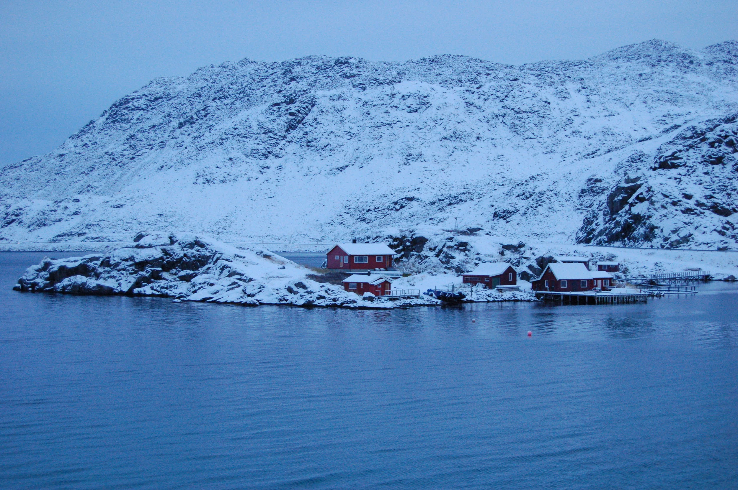 Eksempel på lokal klimatilpassing frå Nordkapp kommune. Bygningane er plassert i ly mellom to knausar ute på odden. Foto: Tore Kvande