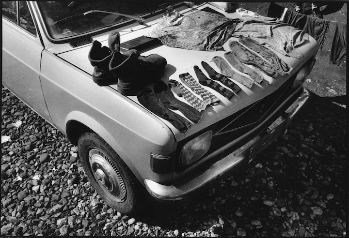 Refugee laundry drying on a Yugo car in the grounds of a potato processing factory near a refugee camp in Kukes, Albania.