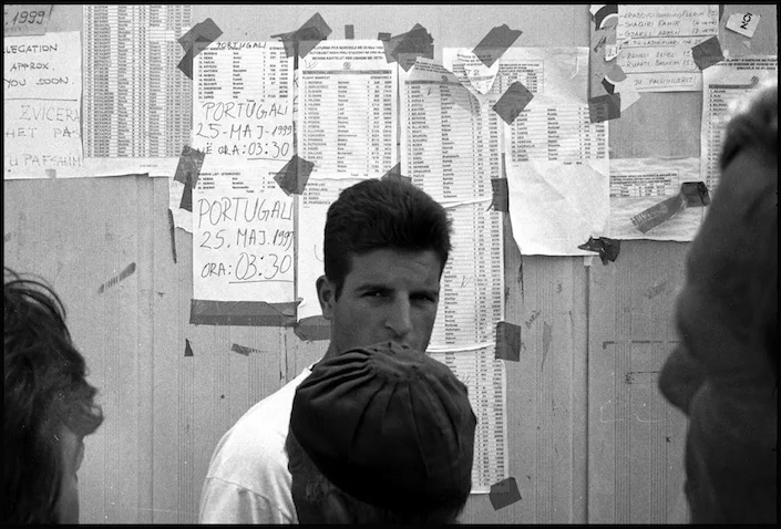 Newly arrived refugees in Cegrane refugees camp search through ICRC lists for the name of family and friends who have been given asylum in other countries.