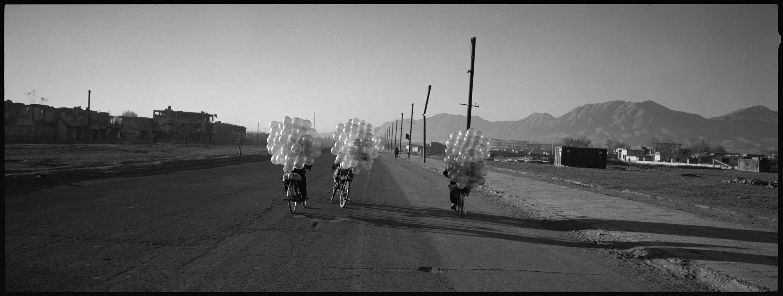  Cyclists selling balloons in one of the destroyed areas of Kabul. During the Taliban regime balloons were banned.

 