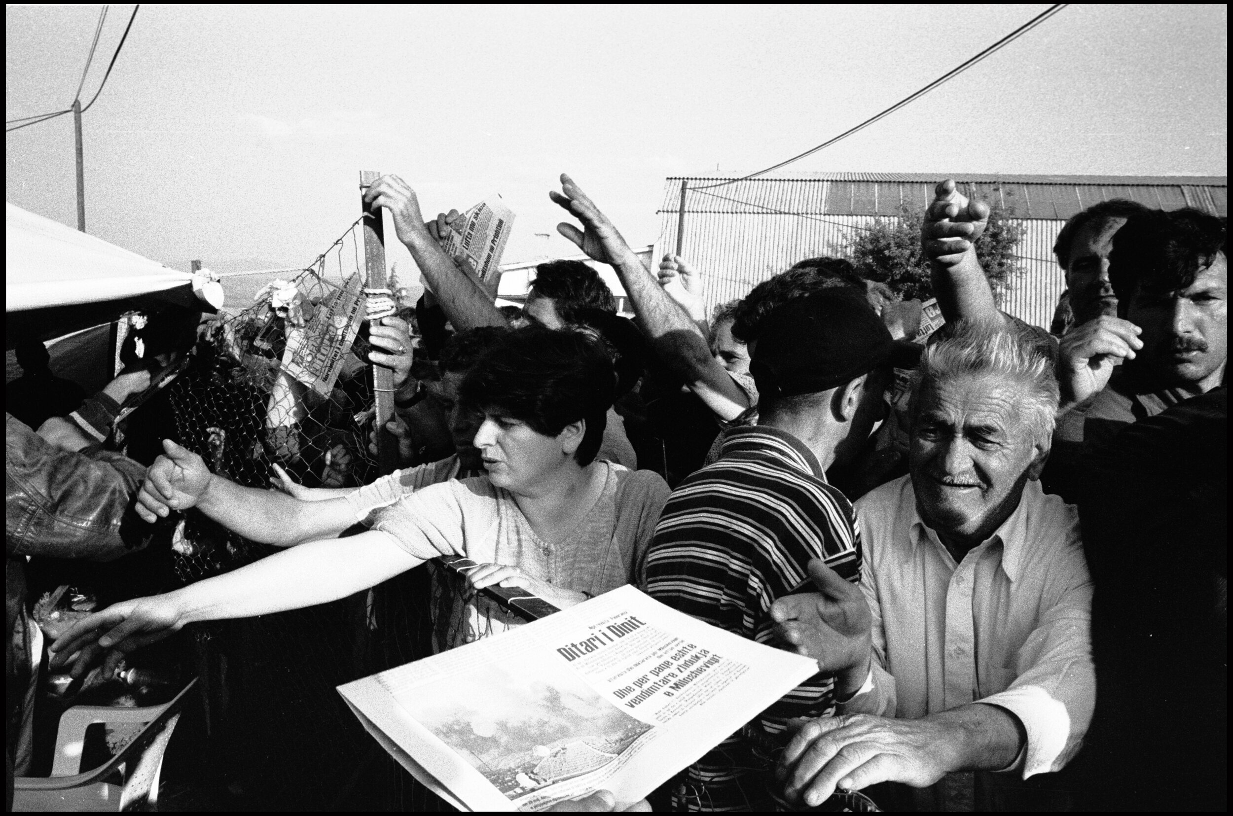  Refugees clamour for the morning edition of the Kosovar newspaper  Koha Dittore  which was printed in exile in Stankovic refugee camp, Macedonia. 