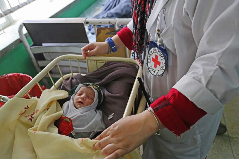 An ICRC senior medical officer checks on a baby who was delivered by C-section. Where there is no safe access to health care locally, women who have had complications often endure long and painful journeys over dangerous roads to reach help. ICRC/W Carter