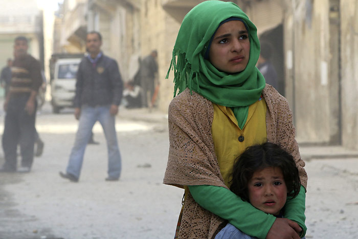 6 March 2014. Girls stand as they look at a site hit by a bomb in Aleppo's al-Sakhour district. ©Reuters / Hosam Katan