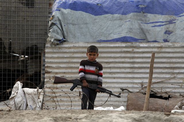 ATT - What remains to be done - Boy With AK-47, Iraq - Photo courtesy of Reuters/Thaier Al-Sudani