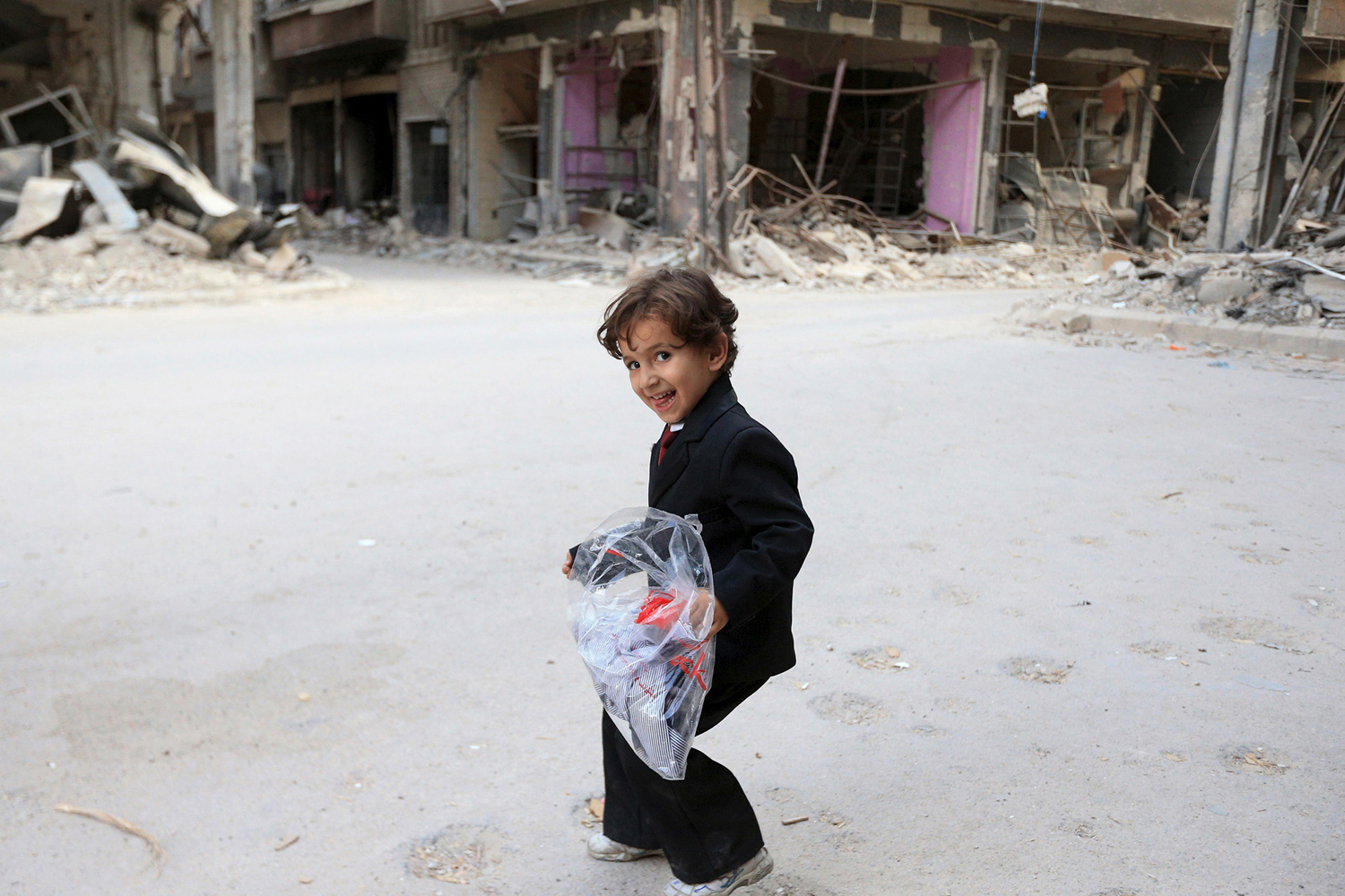 Our photo of the week was taken from an Atlantic photo gallery titled "Syria's Children." In this photo a boy carries a bag of new clothes ahead of the Eid al-Fitr holiday marking the end of Ramadan in Jobar, a suburb of Damascus, Syria, on July 15, 2015. © Bassam Khabieh / Reuters