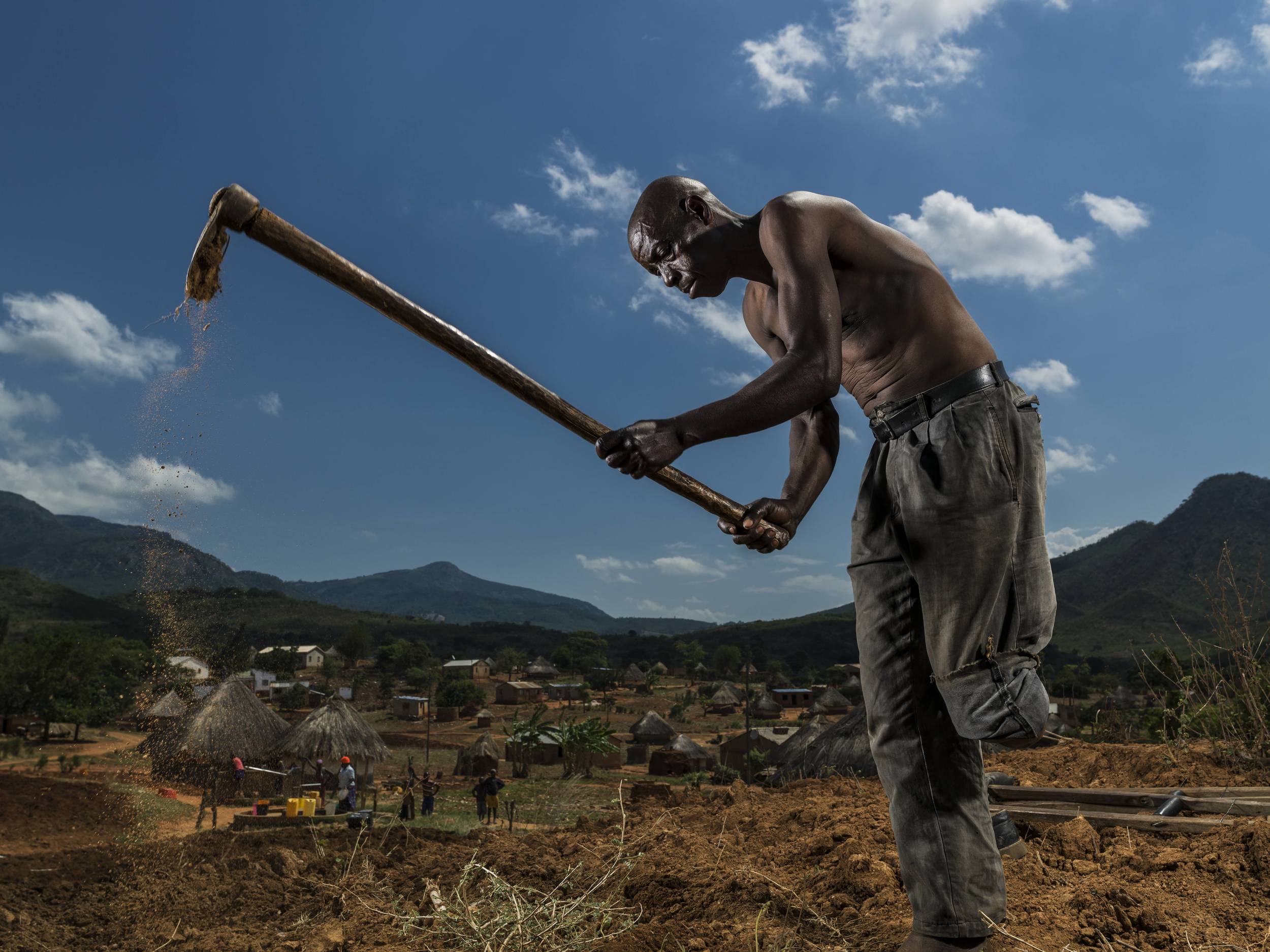 BARRIO CHIUIJO, MOZAMBIQUE: Bonafacio Muazia, 57, lost his left leg to an anti-personnel landmine in 1985 during the civil war. However, he continues to farm, having developed extraordinary balance. With his wife carrying the hoe, every day he hobbles 45 minutes each way to his garden. Brent tirton/Getty Images/ICRC.