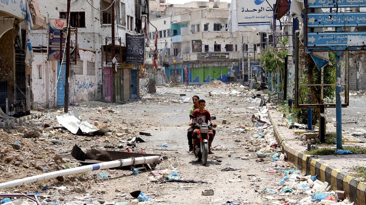 Taiz, Yeman. This once vibrant street is now devastated and overrun with snipers. Despite the danger, two men on a motorcycle drive through the area. CC BY-NC-ND/ICRC/W. Al-Absi