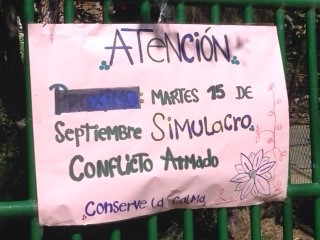 A notice on the school gate informs arrivals that there will be an "armed conflict simulation" and to "stay calm."