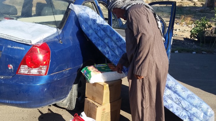 Um Arrizam, Libya, 14 October 2015. A man loads his car with household items. The ICRC distributed essential household supplies to 1,320 internally displaced persons from Derna, Alfatayih and Benghazi who have taken refuge in and around Um Arrizam. CC BY-NC-ND / ICRC / Fares Elabeid