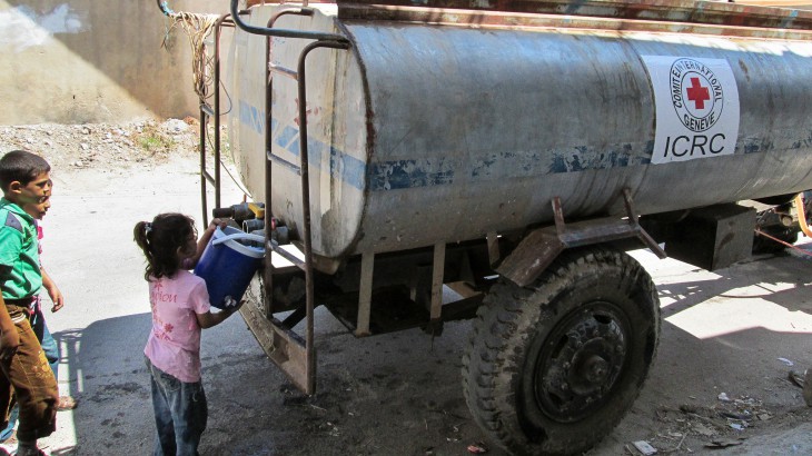 Homs, Syria. A displaced girl stocks up on water from an ICRC water truck. CC NY-NC-ND/ICRC/SY-E-00308