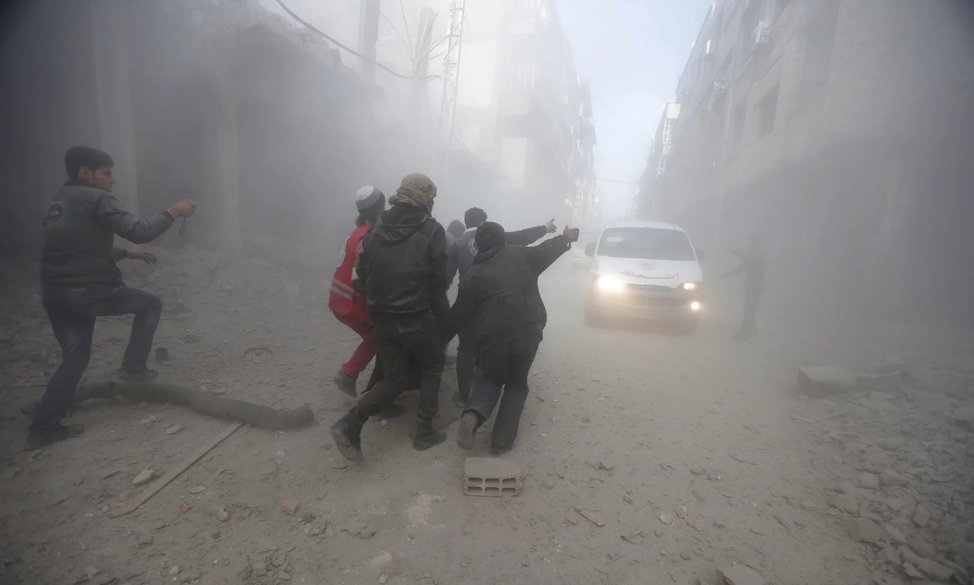  Residents and a member of the Syrian Red Crescent carry an injured man, after an air-strike in eastern Ghouta. The ICRC explains to warring parties practical ways to reduce civilian deaths. ©Bassam Khabieh/Reuters