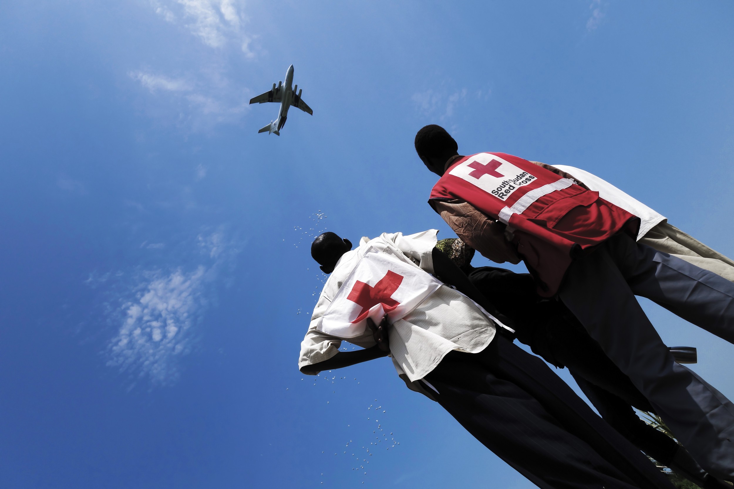 Unity State, Leer. South Sudan Red Cross volunteers look at the ICRC plane dropping assistance. ©KRZYSIEK, Pawel/ICRC