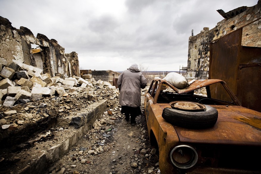 Bolshaia Vergunka village, Lugansk region: Valentina Gregorievna at the ruins of her house that was completely damaged due to the proximity to the front line. She was a wall painter and her husband was builder. They built the house with their own hands and raised 2 children. Her husband was killed. ©Pieter-Jan De Pue/ICRC