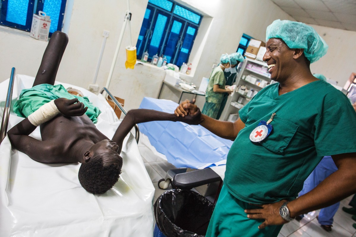 ICRC Surgeon Manuel Lopez greets a patient that recently underwent an amputation after being shot while herding his cattle. ©Albert Gonzalez Farran/ICRC