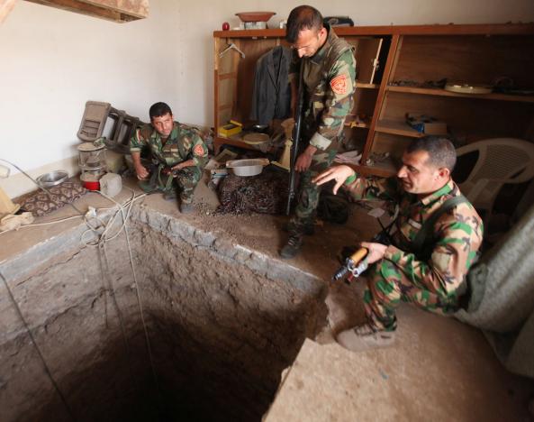 Peshmerga forces stand around a tunnel believed to beused by the Islamic State Group on the outskirts of Bartila. REUTERS/Azad Lashkari